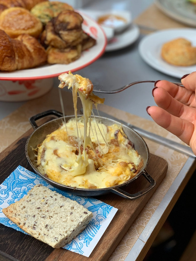 Cacerola de huevos y queso acompañada de pan.