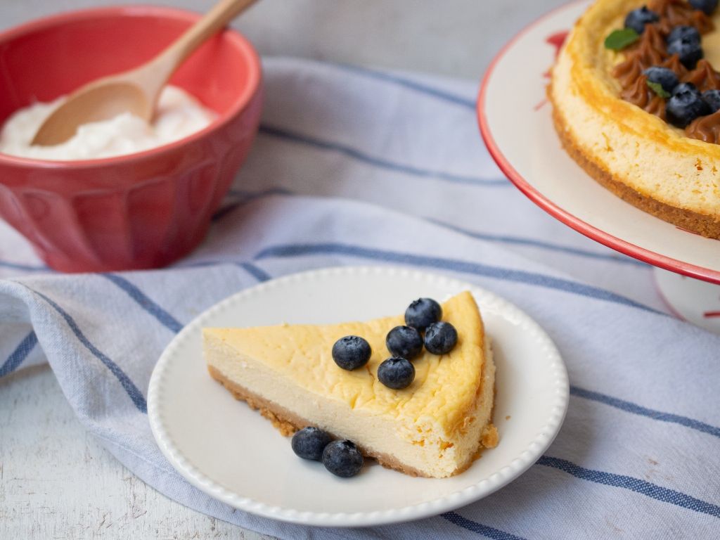 Una porción de cheesecake saludable servido con arándanos.