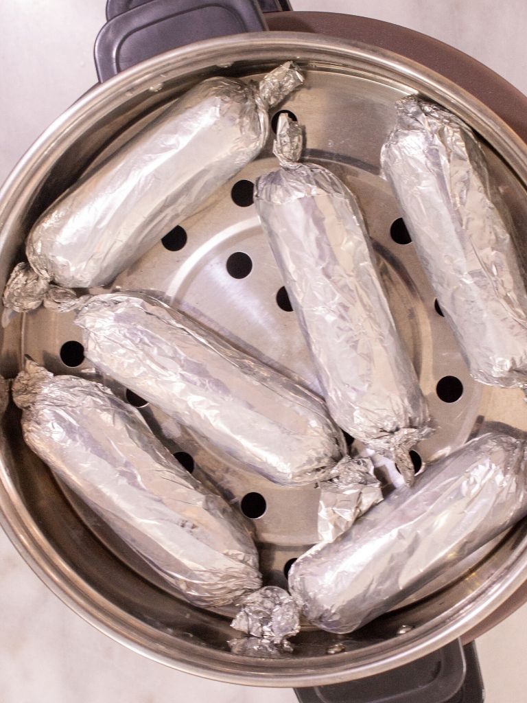 Los bollos limpios envueltos en papel aluminio cocinándose sobre una vaporera.